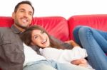 Cheerful Young Couple Relaxing On Sofa Stock Photo