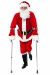 Santa Walking With The Help Of Crutches Stock Photo