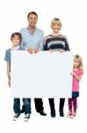 Active Young Family Displaying Blank Ad Board Stock Photo
