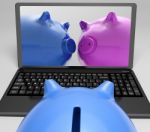 Piggybanks On Notebook Showing Online Transactions Stock Photo