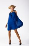 Attractive Young Woman In A Blue Dress Standing In The Studio Stock Photo