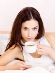 Woman Holding Cup Of Coffee In Bed Stock Photo