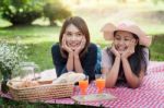Two Asian Girlfriends Lying On The Lawn, Women In Park During Th Stock Photo