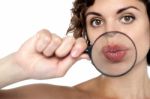 Lady Holding Magnifying Glass In Front Of Her Lips Stock Photo