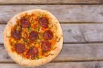 Delicious Baked Salami Pizza Served On Rustic Wooden Table Stock Photo