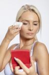 Young Woman Clean Face With Wet Wipes, Looking On Mirror In Hand Stock Photo