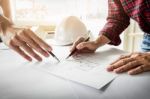Architects Engineer Discussing At The Table With Blueprint - Clo Stock Photo
