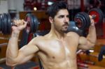 Young Man Doing Heavy Weight Exercise In Gym Stock Photo