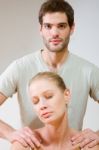 Man Massaging Womans Shoulders Stock Photo