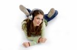 Female Lying And Listening Music Stock Photo