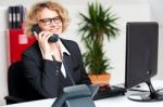 Happy Front Desk Lady Attending Clients Call Stock Photo