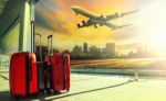 Traveling Luggage In Airport Terminal Building And Jet Plane Flying Over Urban Scene Stock Photo