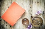 Teapot And Red Book On Old Wooden Background Stock Photo