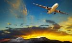 Plane Flying Against Beautiful Sun Rising Sky For Traveling Theme Stock Photo