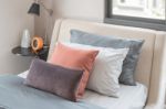 Brown Pillows On Modern Bed In Bedroom Stock Photo