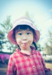 Cute Little Asian Girl Eating A Lollipop On Nature Background In Stock Photo