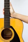 Woman's Hand Holding Acoustic Guitar On White Background Stock Photo