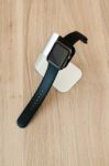 Apple Watch In Stand On Wooden Table Stock Photo