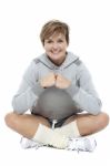 Adorable Woman In Sports Wear Sitting On The Floor Stock Photo