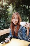 Happy Young Woman Drinking Coffee Outdoors And Using Smartphone Stock Photo