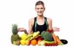 Young Smiling Girl Presenting Fresh Fruits Stock Photo