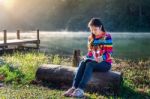 Young Girl Reading A Book In The Park Stock Photo