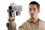 Young Man Looking In To Video From Handy Cam Stock Photo