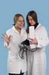 Two Women Doctors A Over Blue Background Stock Photo