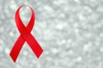 Red Ribbon Sign On Silver Bokeh Background Stock Photo