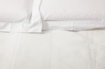Double Bed With White Linens Stock Photo