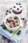 Bowl Of Muesli With Fresh Blueberries And Glass Of Yogurt On Whi Stock Photo