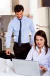 Couple With Computer In Kitchen Stock Photo