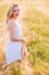 Lonely Beautiful Young Blonde Girl In White Dress With Straw Hat Stock Photo