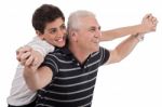 Piggyback Ride Given By Grandfather Stock Photo