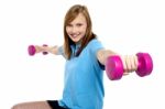 Cute Young Girl Stretching Dumbbells Sideways Stock Photo