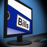 Bills On Monitor Showing Paying Expenses Stock Photo