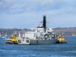 Hms Albion Being Towed Into Portsmouth Harbour Stock Photo