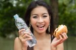 Young Woman Enjoying A Chicken Burger Stock Photo