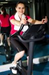 Athletic Woman Cycling At The Gym Stock Photo