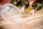 Red Wine Bottle, Glass And Grape Shaped Corks On Wooden Table Stock Photo