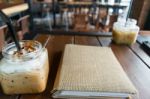 Coffee, Iced Coffee Mocha And Blur Menu Book On Table Wood Stock Photo