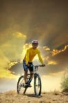 Young Man Riding Moutain Bike Mtb On Land Dune Against Dusky Sky Stock Photo