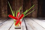 Red Hot Chilli Peppers And Green Onions In Glass Of Water Stock Photo