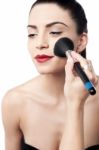Pretty Woman Applying Makeup With Brush Stock Photo