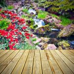 Wooden Deck Floor And Red Rhododendron Flowers Stock Photo