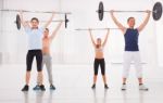 Multiethnic Group Of People Exercising With Weightlifting Bar In Stock Photo