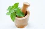 Mint Leaves In Wooden Mortar On White Wooden Background Stock Photo