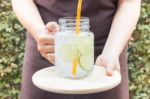 Hand On Serving Glass Of Iced Lime Soda Drink Stock Photo