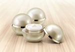 Golden Sphere Cosmetic Jar On Wood Background Stock Photo