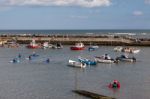 People Enjoying Themselves In Staithes Harbour North Yorkshire Stock Photo
